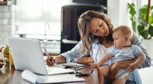 Maman en télétravail avec son bébé, jonglant entre carrière, parentalité et charge mentale