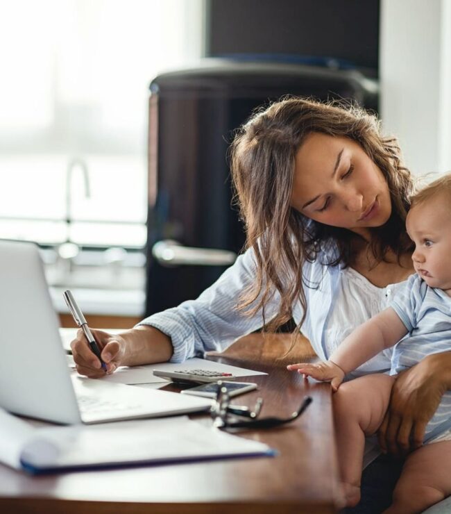 Maman en télétravail avec son bébé, jonglant entre carrière, parentalité et charge mentale