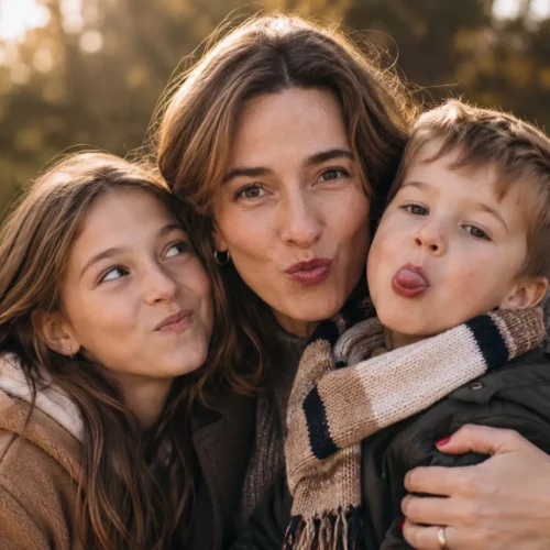 avoir une fille et un garcon choix de la reine famille slow maman bebymaman Maman de 40 ans enlacée avec sa fille de 10 ans et son garçon de 4 ans, tous les trois faisant une grimace complice lors d'une balade en forêt, illustrant la joie d'avoir une fille et un garçon dans une famille slow.