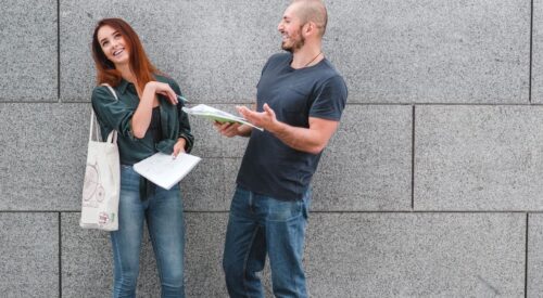 Homme et femme complices discutant dans la rue, symbolisant une rencontre inattendue entre anciens partenaires.