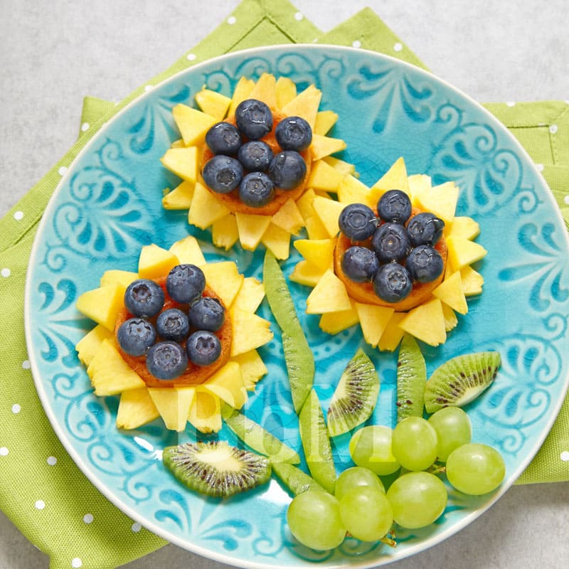 salade de fruit printemps fleurs assiette creative cusine alimentation vegetarienne bebymaman Assiette printanière de fruits décorés en forme de fleurs, avec myrtilles, ananas, kiwi et raisin.