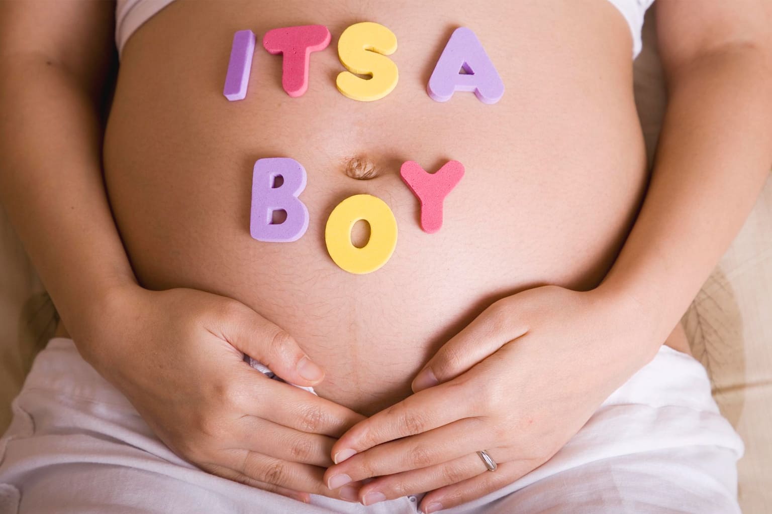 Ventre de future maman avec les lettres “It’s a boy” pour annoncer l’arrivée d’un petit garçon