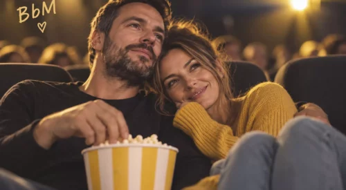 Couple d’environ 35 ans enlacé au cinéma avec popcorn, illustrant l’amour après le premier chapitre
