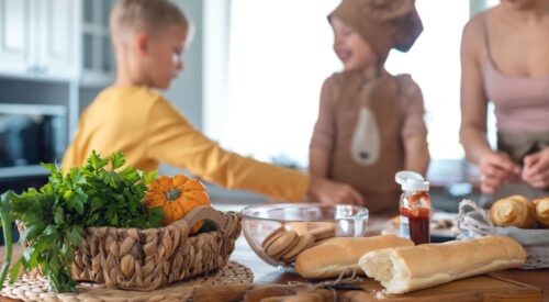 Maman et enfants qui cuisinent ensemble un repas du mercredi à la maison