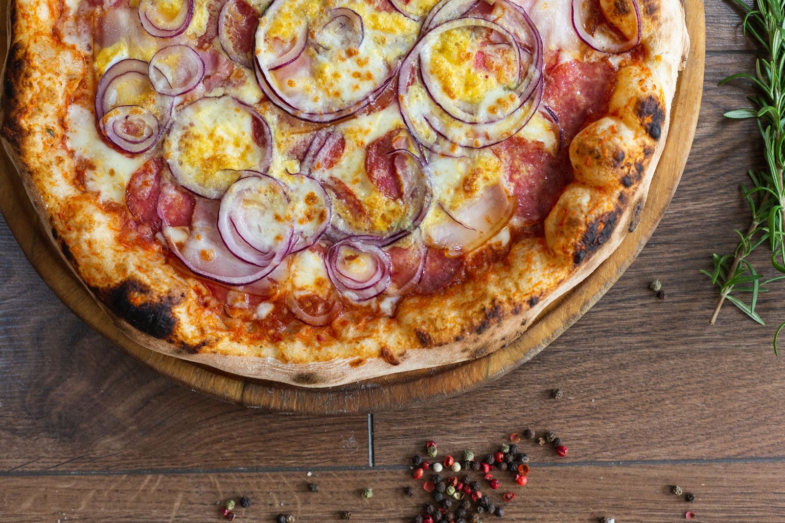Pizza maison dorée au four avec mozzarella fondue et oignons rouges
