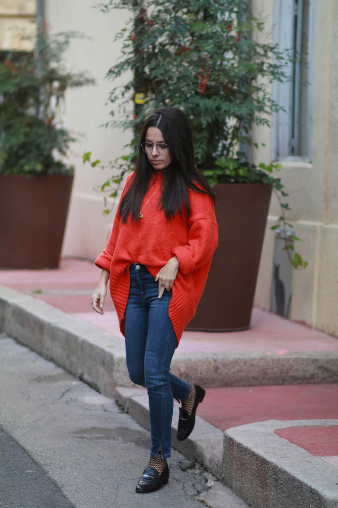 look1 automne Femme portant un pull oversize orange avec un jean slim et des mocassins noirs, look casual chic d’automne