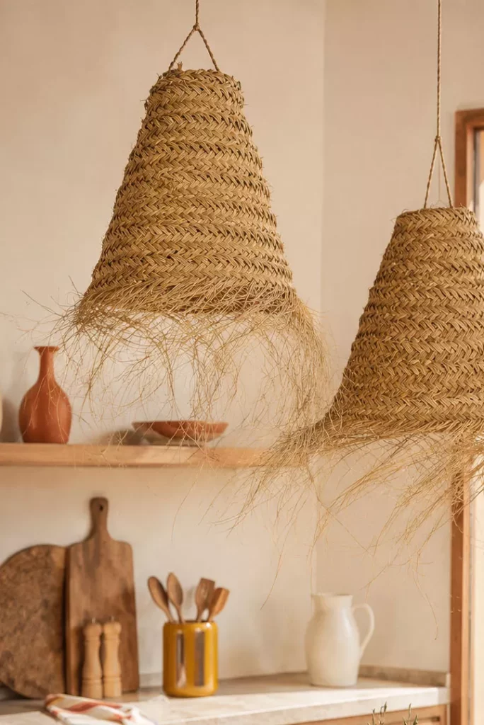 2.0inspiration bord de mer decoration suspension Suspensions en paille tressée artisanales installées au-dessus d'une table dans une cuisine esprit bord de mer aux accents méditerranéens.