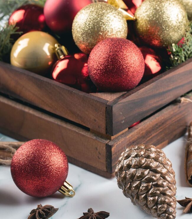 décoration de Noël naturelle et chaleureuse, boules rouges et dorées avec pommes de pin et cannelle – ambiance festive Be by Maman