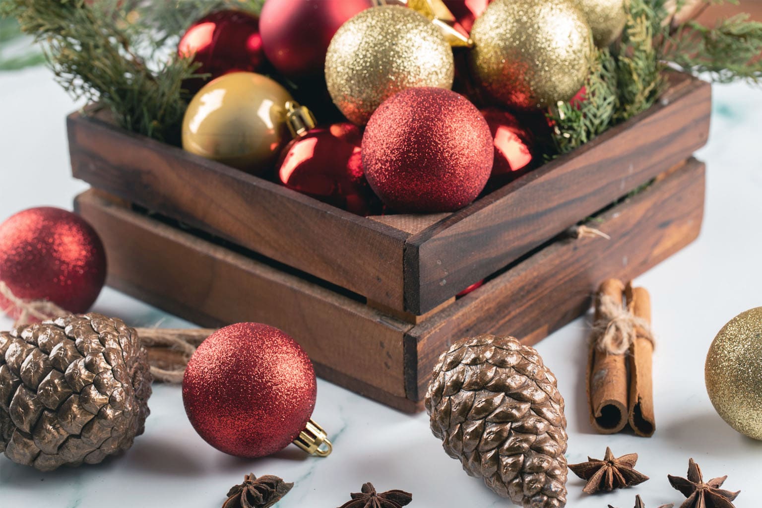 décoration de Noël naturelle et chaleureuse, boules rouges et dorées avec pommes de pin et cannelle – ambiance festive Be by Maman