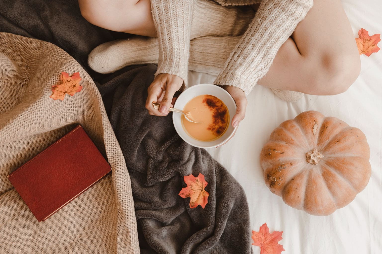 femme en pull beige dégustant une soupe de potiron dans une ambiance cocooning d’automne – bien-être et slow life Be by Maman