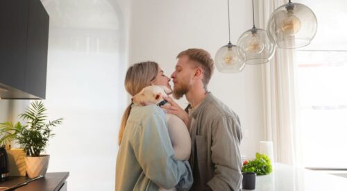 couple s’embrassant tendrement dans la cuisine – relation amoureuse à la maison – complicité conjugale et équilibre famille