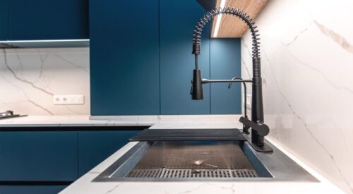 cuisine moderne bleu et blanche avec robinet noir design et plan de travail effet marbre