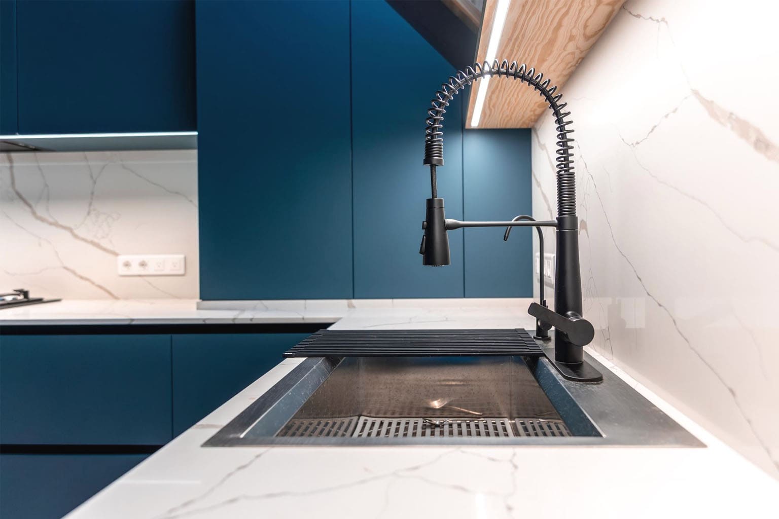 cuisine moderne bleu et blanche avec robinet noir design et plan de travail effet marbre