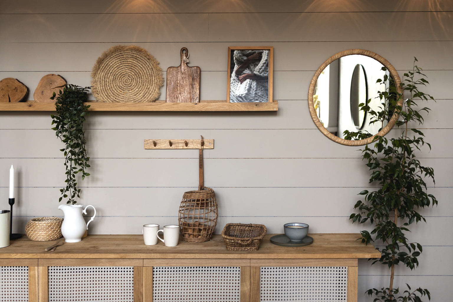 Cuisine moderne chaleureuse avec déco naturelle en bois et rotin, étagère murale stylée et miroir rond.