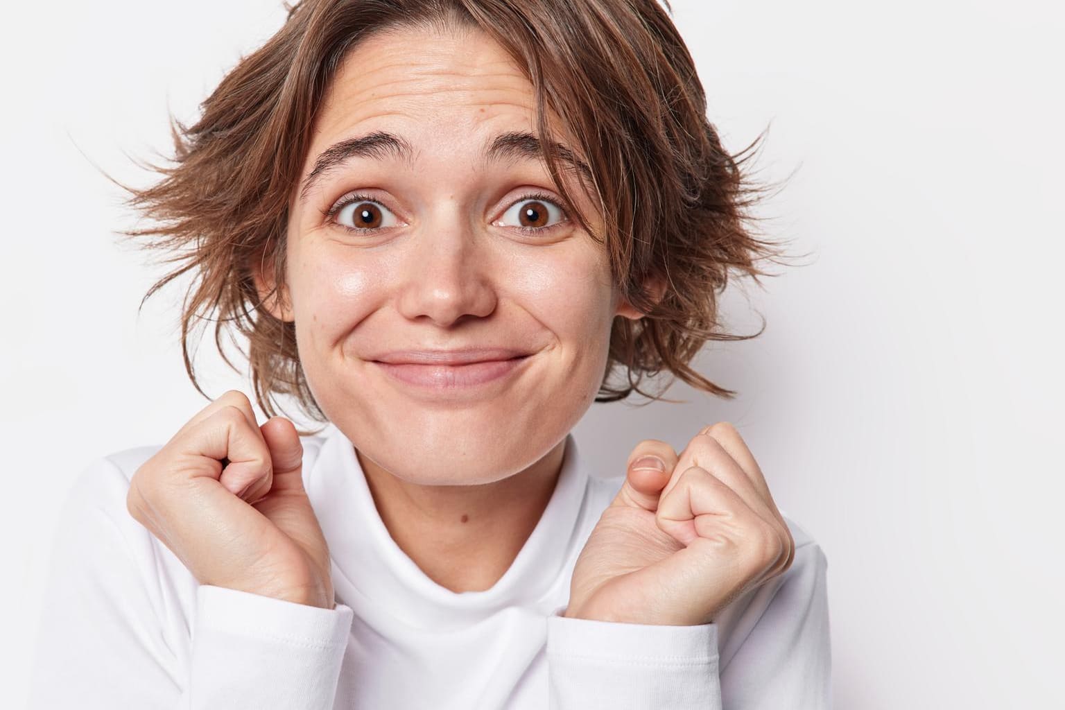 Femme naturelle souriante sans maquillage, cheveux courts, expression spontanée de bien-être et de confiance en soi.