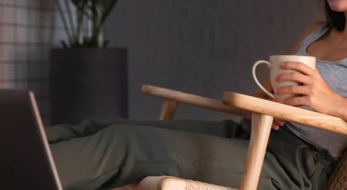 Femme travaillant depuis son domicile avec une tasse de thé, illustration d'un métier flexible et compatible avec l'intelligence artificielle pour concilier carrière, famille et équilibre de vie.