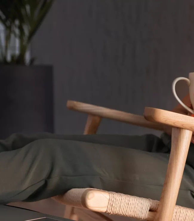 Femme travaillant depuis son domicile avec une tasse de thé, illustration d'un métier flexible et compatible avec l'intelligence artificielle pour concilier carrière, famille et équilibre de vie.