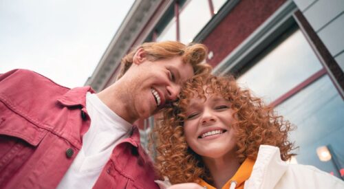 Amitié homme femme en extérieur, deux amis qui rient ensemble et partagent un moment complice