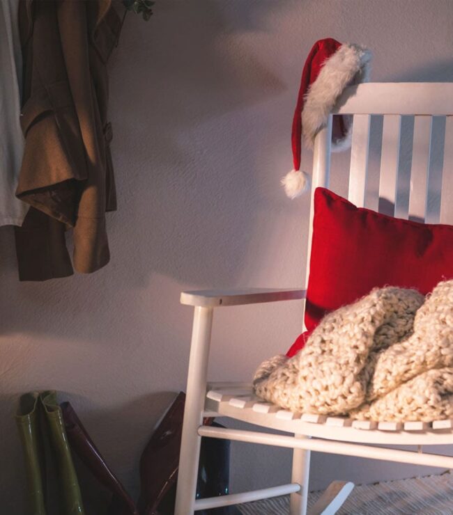 Fauteuil blanc cosy avec plaid en laine et coussin rouge, ambiance maison après Noël, déco hivernale apaisante et slow home en janvier