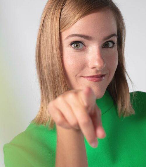 Femme souriante pointant vers l’objectif, incarnant la réussite personnelle et l’équilibre de la maman d’aujourd’hui