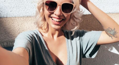 Femme souriante aux cheveux blonds lumineux, coiffure tendance printemps été 2026, style naturel et summer vibes