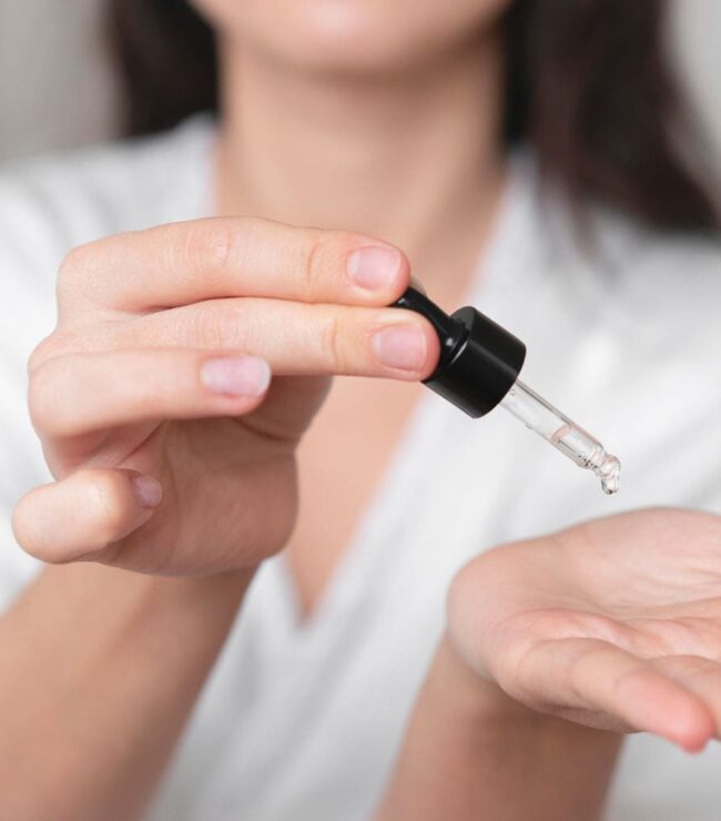 Femme appliquant un sérum sur la main.