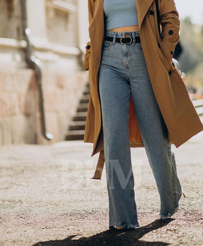 jeans droit flare dressing tendance mode femme quadra bebymaman Jean droit légèrement flare porté par une femme active de 40 ans avec trench camel et top ajusté, look tendance maman quadra moderne – Be by Maman