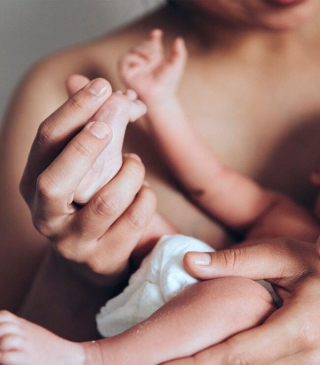 maman tenant son nouveau-né dans les bras après la naissance peau à peau moment maternite allaitement ou biberon