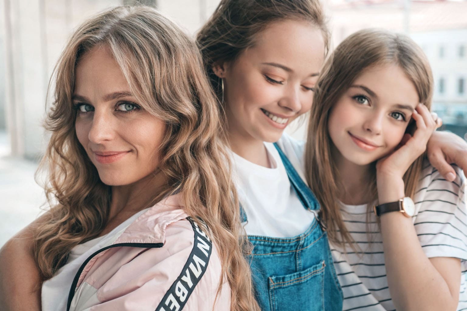 Alt (riche SEO) Maman quadra souriante entourée de deux jeunes femmes, illustration de la transmission et de l’équilibre entre féminité, famille et épanouissement après 40 ans.