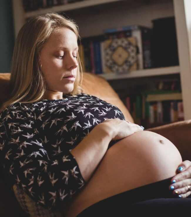 femme enceinte assise regardant son ventre avec émotion mal vivre sa grossesse témoignage future maman