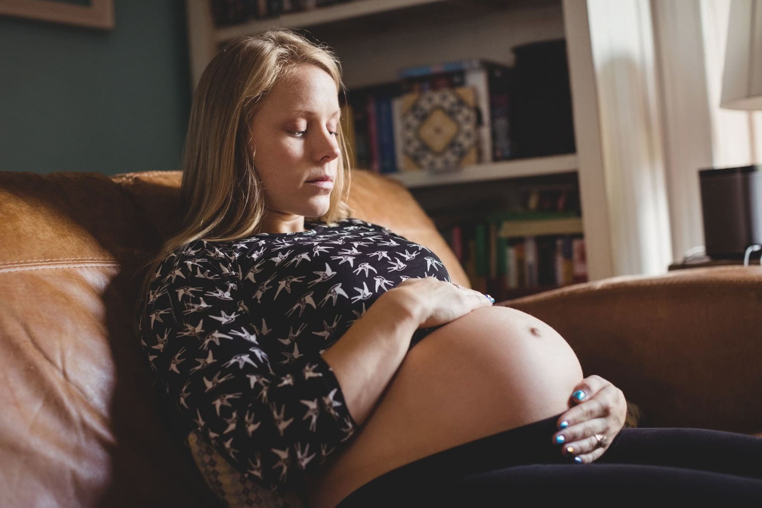 femme enceinte assise regardant son ventre avec émotion mal vivre sa grossesse témoignage future maman