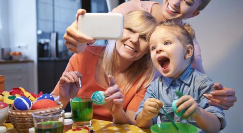 Activité de Pâques en famille avec enfants décorant des œufs colorés autour d’une table
