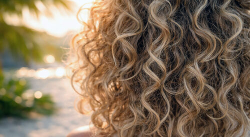 boucles naturelles en gros plan au soleil coiffure été cheveux bouclés
