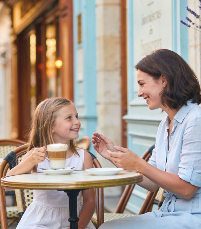 Maman et sa fille partageant un moment complice en terrasse, illustration du slow living en famille et du temps de qualité au quotidien