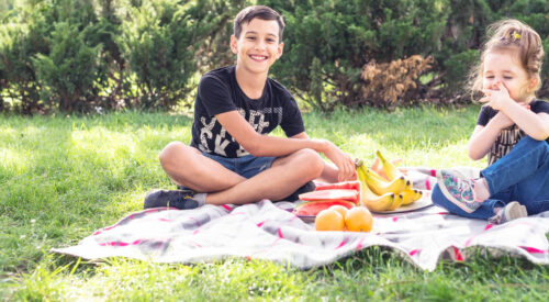 Vacances de Pâques en famille : enfants en pique-nique dans le jardin, moment simple et joyeux slow family