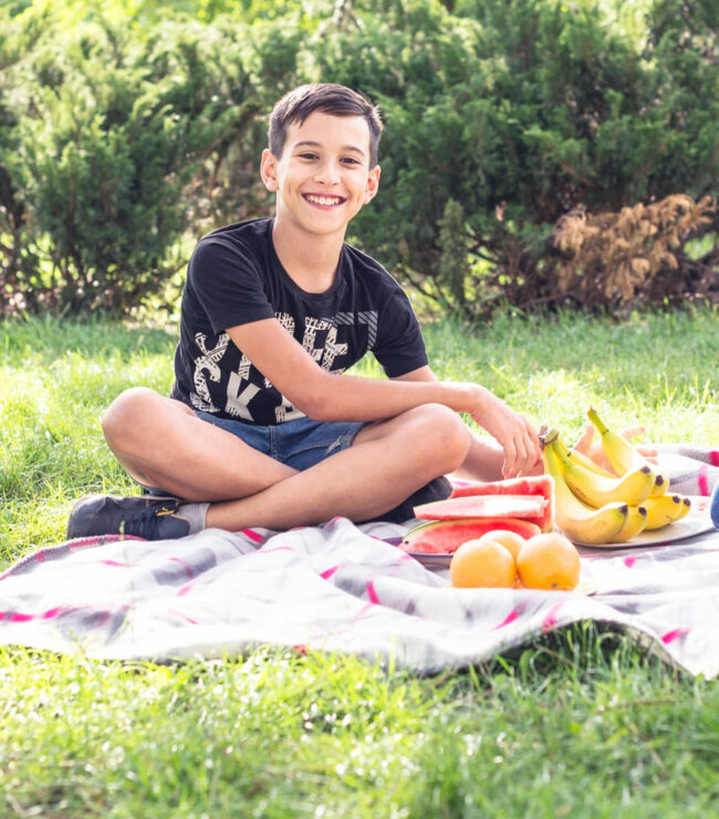 Vacances de Pâques en famille : enfants en pique-nique dans le jardin, moment simple et joyeux slow family