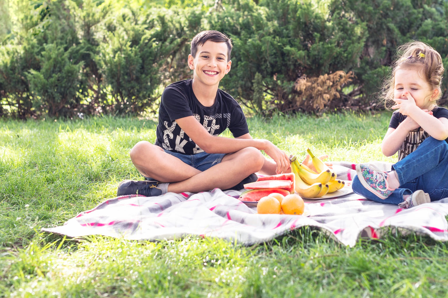 Vacances de Pâques en famille : enfants en pique-nique dans le jardin, moment simple et joyeux slow family