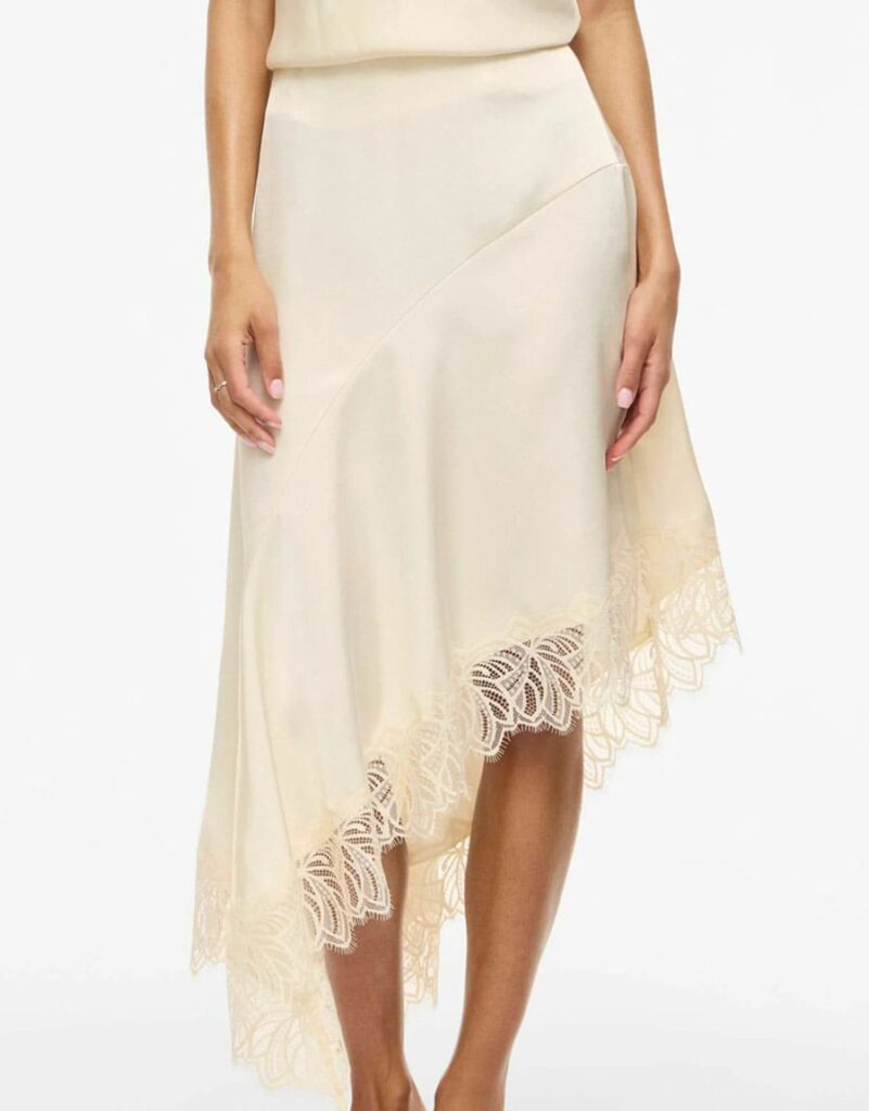 jupe dentelle mode femme 40 ans maman quadra bebymaman Femme portant une jupe longue satinée asymétrique beige avec dentelle VILA, tendance mode femme quadra chic été 2026