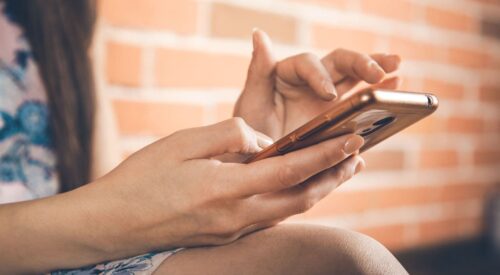 ALT Femme utilisant son téléphone portable et scrollant sur les réseaux sociaux dans un contexte de charge mentale numérique