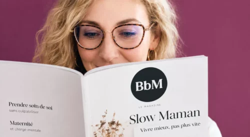 Mila Clapelin lit un magazine Slow Maman dans un portrait rapproché illustrant la FAQ de Be by Maman et les questions les plus fréquentes sur son parcours, sa philosophie slow et son blog.