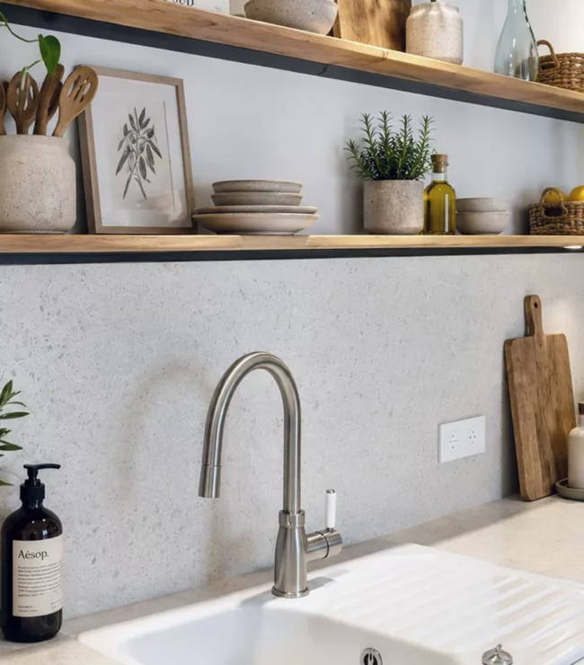 Étagères sans équerre en bois et métal noir dans une cuisine moderne avec crédence terrazzo et décoration naturelle