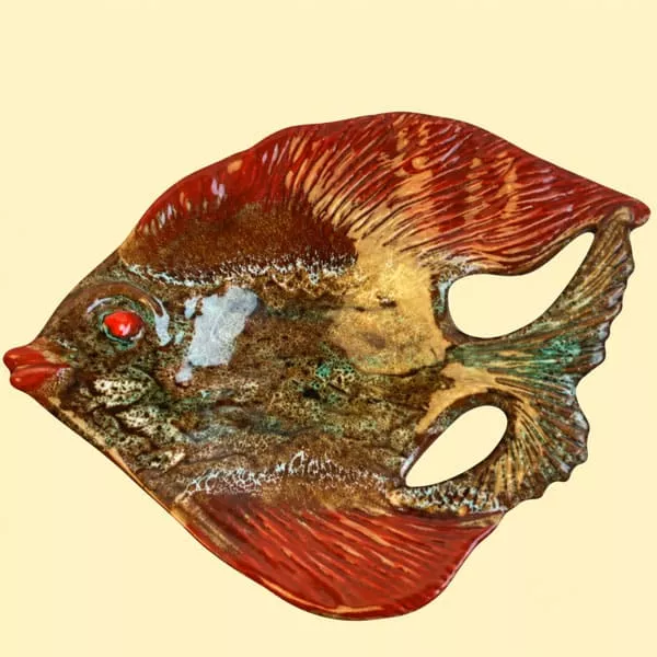 plat emmau art de la table inspiration sud france Plat en céramique en forme de poisson aux tons ocre, verts et bruns, avec nageoires rouges.